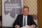 Oliver Dowden signing the Book of Commitment. Photo Credit: Holocaust Educational Trust